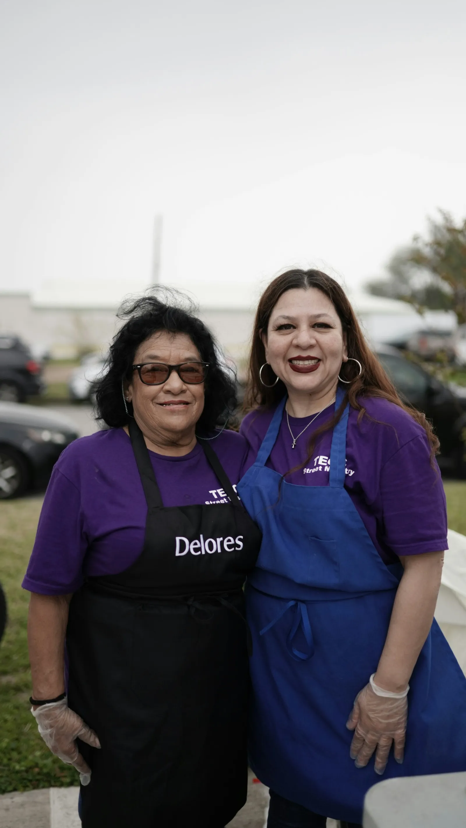 Two smiling volunteers in aprons
