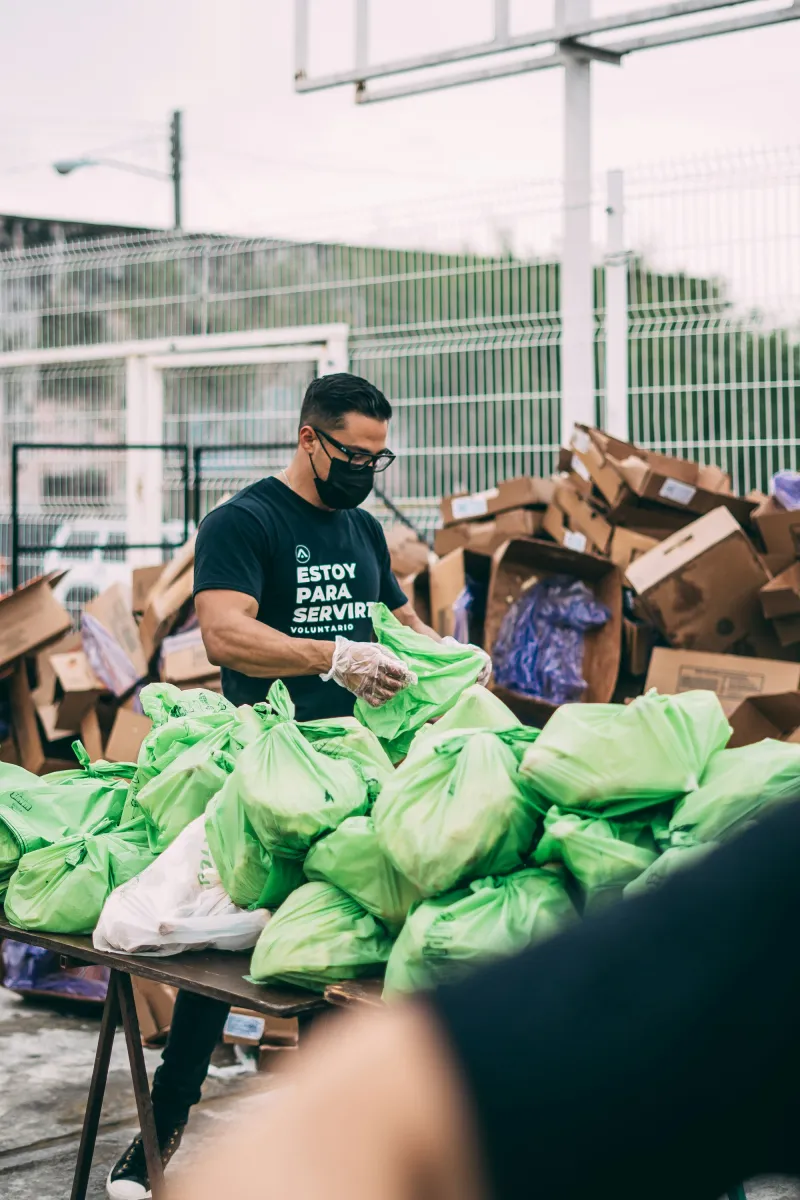 A volunteer handing out bags of fresh food